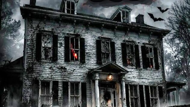 A dilapidated, haunted-looking two-story house at night with broken windows and eerie red glow from the windows, surrounded by bare trees and bats flying overhead.